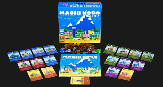 Machi Koro: The Card Game board game set with its blue illustrated box, play mat, cards, tokens, and dice arranged on a white background.