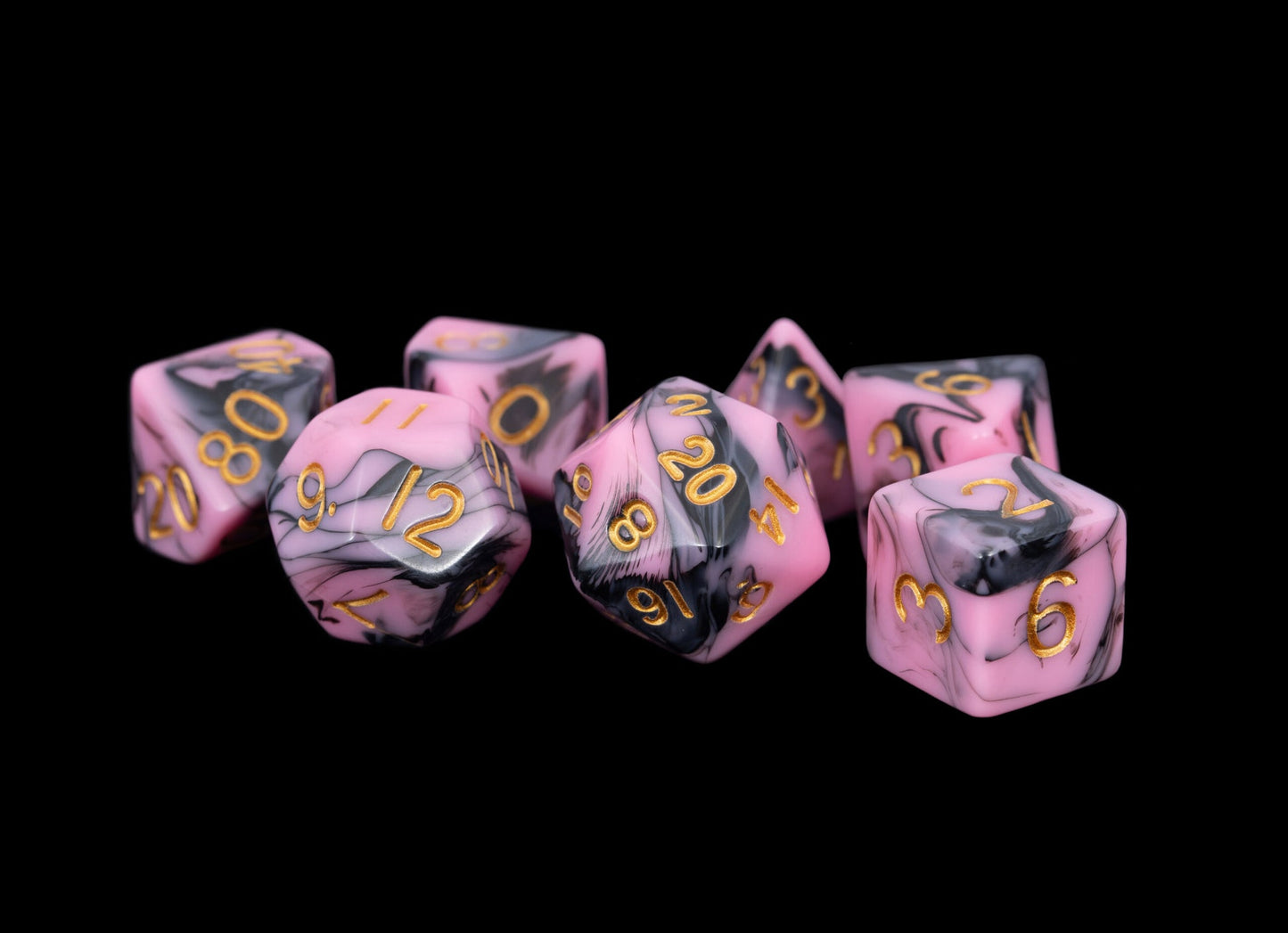 Set of pink and black dice with gold numbers on a black background