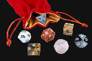Set of dice with a red drawstring bag in the background